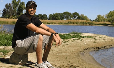 A photograph of Alex Juel at a lake beach.