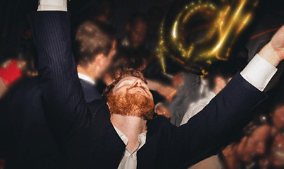 A photograph of Glen McMurry raising his hands above his head. 