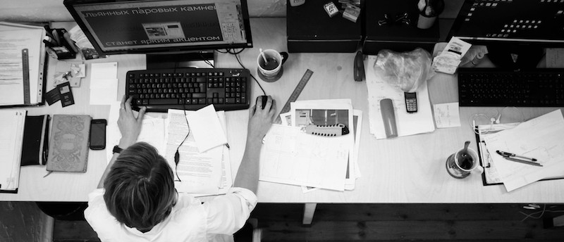 A photograph of above a person working on a computer. 