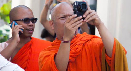 right-people A photograph of two Buddhist monks. One is taking a photograph and the second is talking on a phone.