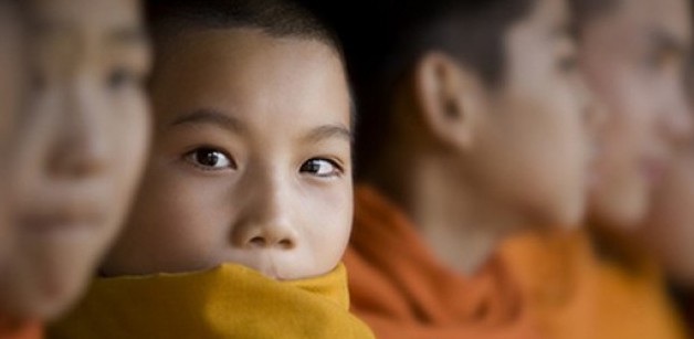 right-person A photograph of a row of young Buddhists with one looking at the camera.