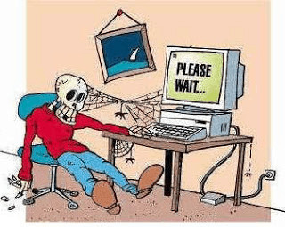 An illustration of a skeleton sitting in front of a computer displaying the text please wait ?. Cobwebs connect the skeleton to the computer. 