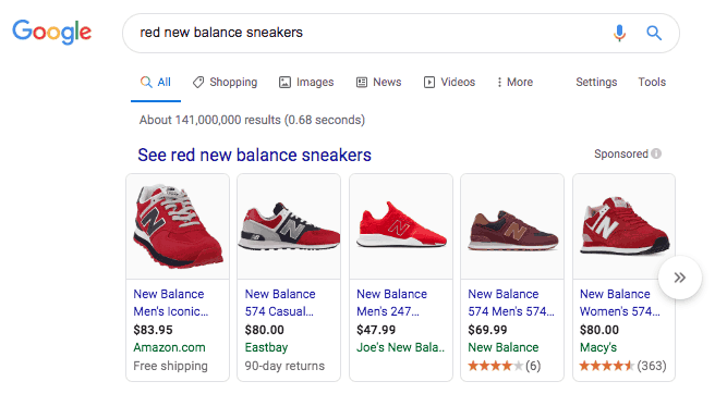 Google search results for red new balance sneakers. Five ads for red New Balance sneakers are displayed in the Shopping Ad horizontal row from five different stores. 