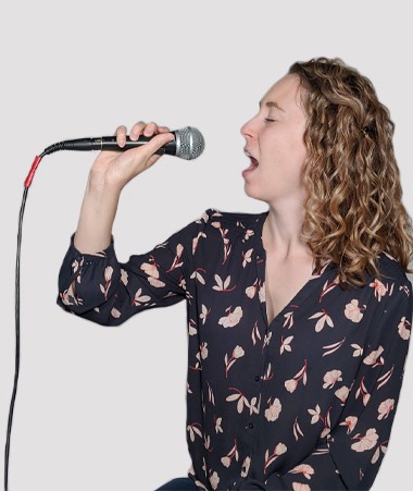 A photograph of Kate Miller singing into a microphone.