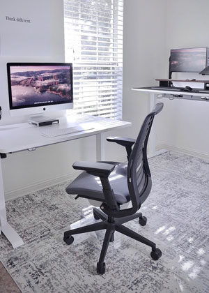 A photograph of a glass chair mat being used in a home office setting. 