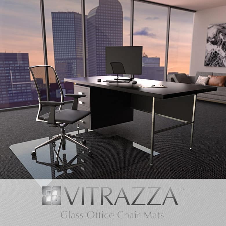 A photograph of a glass chair mat being used in an office setting. Logo: Vitrazza. Glass Office Chair Mats. 