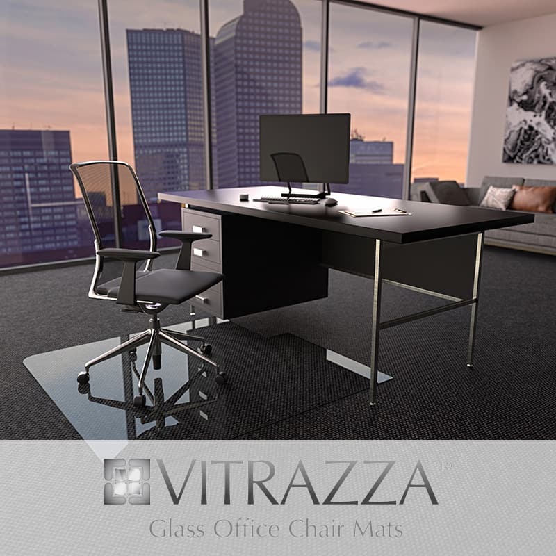 A photograph of a glass chair mat being used in an office setting. Logo: Vitrazza. Glass Office Chair Mats.