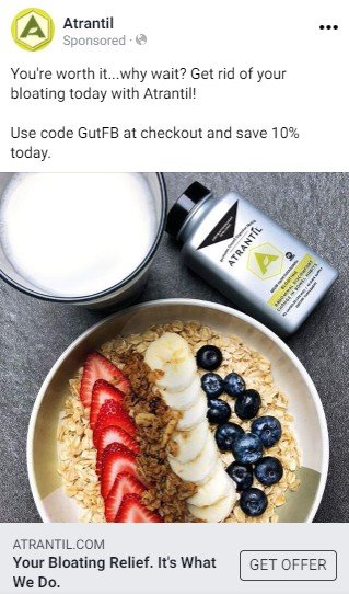 An Atrantil Facebook ad.  A short text advertises Atrantil as getting rid of bloat and offers a discount code. Below the text is a photograph of a bowl of granola topped with fruit, a glass of milk and a package of Atrantil. 