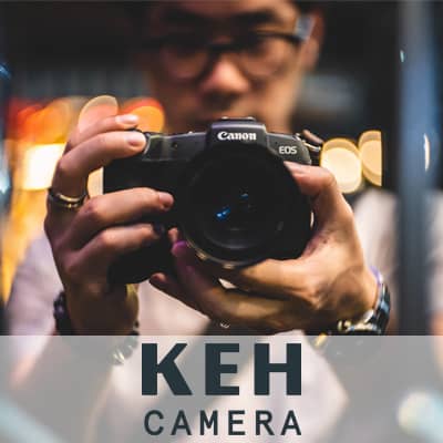 Logo: K E H Camera. A photograph of a man holding a camera.