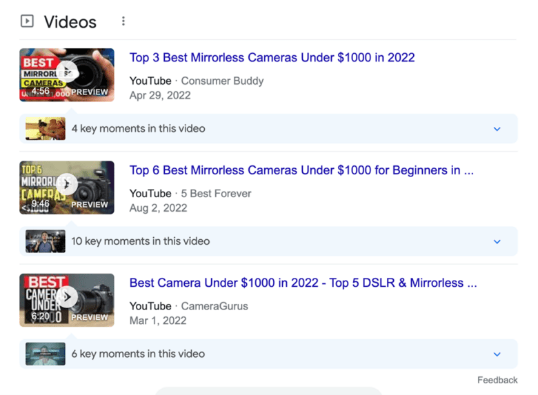 Google video search results for "best mirrorless cameras under $1,000." Video titles: "Top 3 Best Mirrorless Cameras Under $1000 in 2022." "Top 6 Best Mirrorless Cameras Under $1000 for Beginners." "Best Camera Under $1000 in 2022 - Top D S L R & Mirrorless."