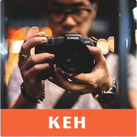 Man holding a camera. Logo: K E H Camera.